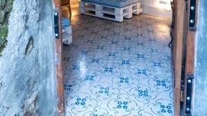 Ein gemütliches, rustikales Interieur mit einer Holzbank, einem kleinen Tisch und einer Sternen-Dekoration an der Wand.