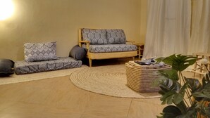 A living room with a sofa set, a coffee table, and a large plant. - 
🏡 Peaceful Family Retreat in Arusha – Near National Parks & City Center (Arusha)