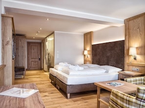 A hotel room with a bed, bedside tables, a desk, and a chair. - DZ Rofan 4-6 ÜN - Hotel Pfandler (Pertisau)