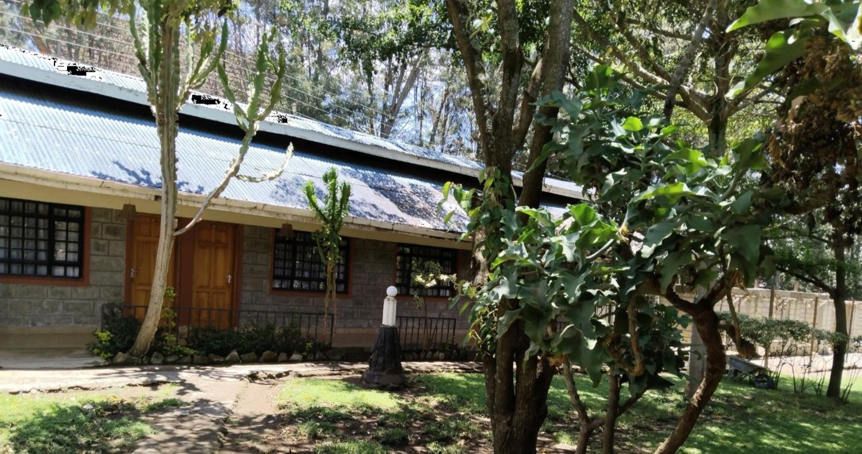 A building with a stone facade, a wooden door, and a metal roof.