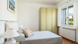 A bedroom with a bed, a lamp, a wardrobe, and a window with curtains. - Sea Shell 28 - a sea-view escape (Olbia)