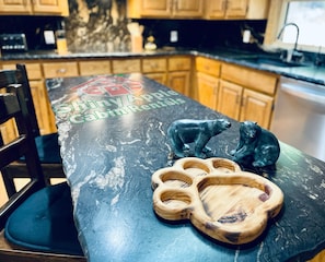 Enjoy cooking in this well-equipped kitchen with a countertop, wooden cabinets, and a convenient backsplash.