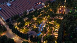 Vue aérienne d’un complexe hôtelier doté d’une grande piscine, de sentiers sinueux et d’une végétation luxuriante.