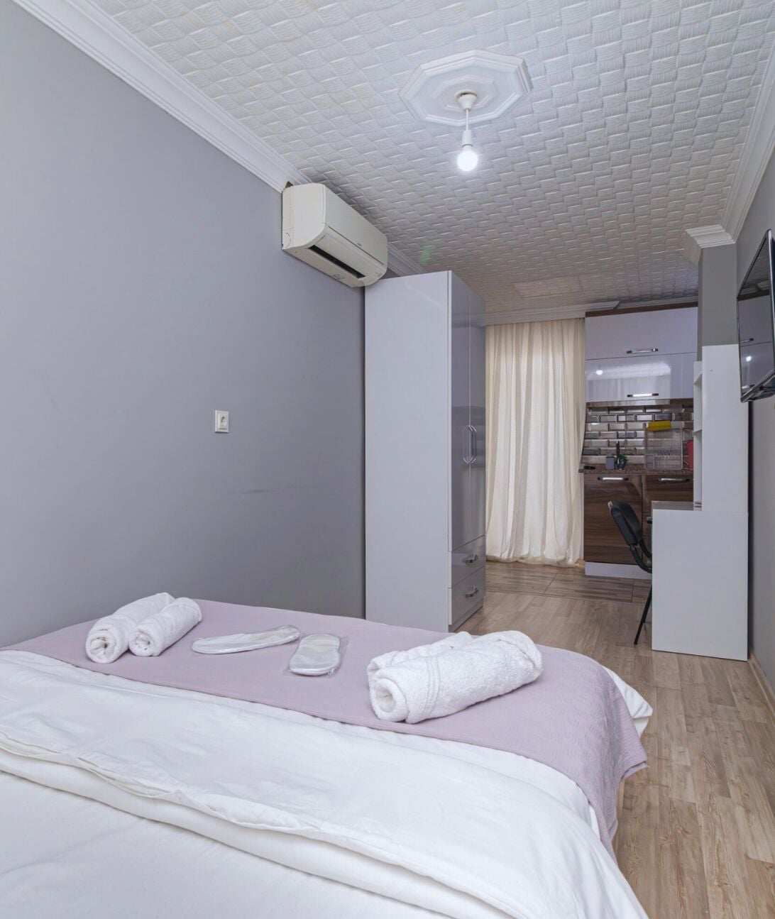 Una camera d'albergo con un letto, un bagno e angolo cottura.