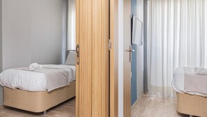 Une chambre d’hôtel comprenant un lit, une armoire et un petit coin salon.