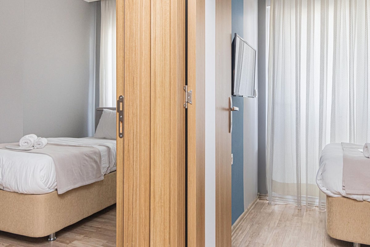 A hotel room with a bed, a wardrobe, and a small seating area.