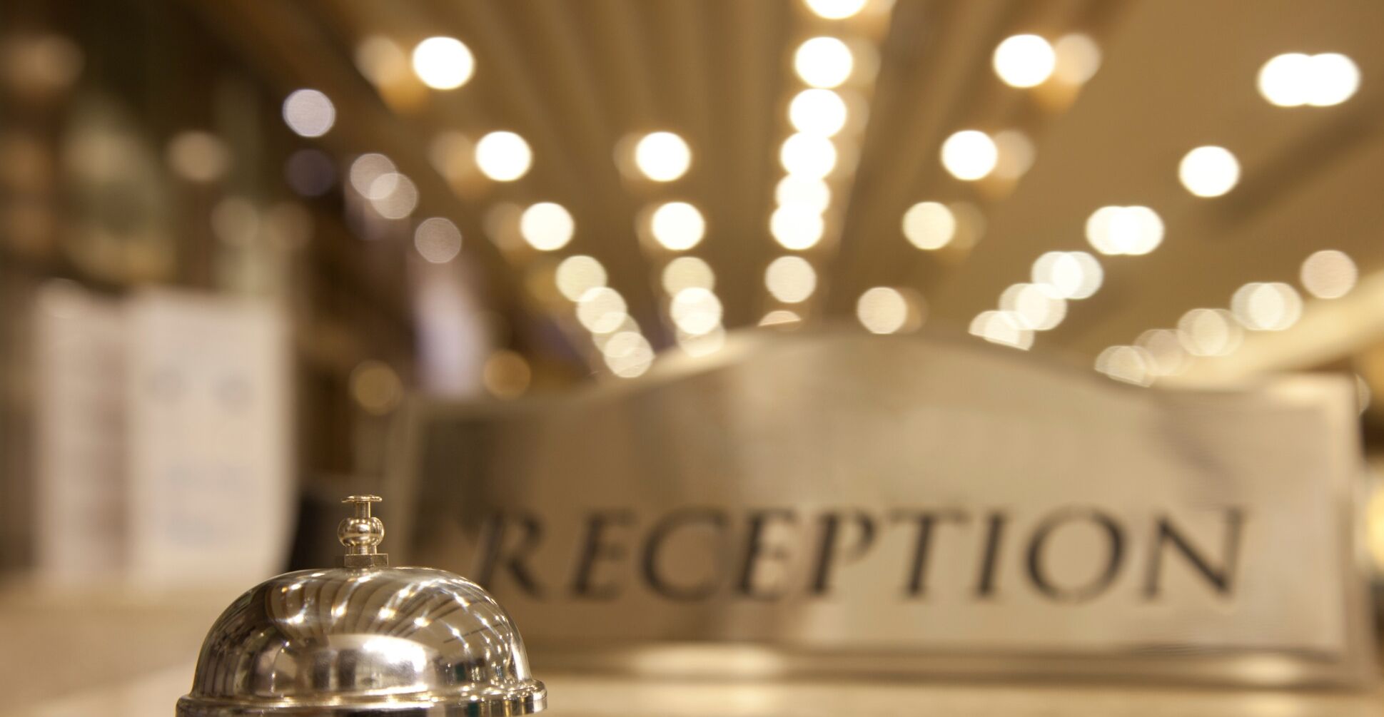 A reception area with a sign labeled "RECEPTION" and a silver bell.