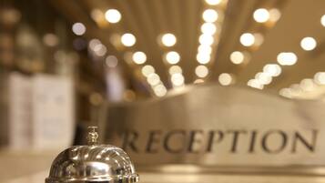 A reception area with a sign labeled "RECEPTION" and a silver bell.
