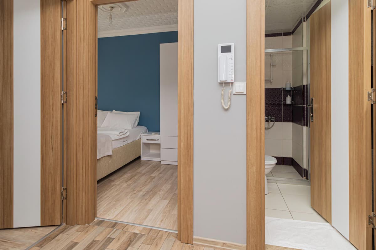 A hotel room with a bed, bedside table, and a telephone.