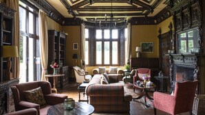 A traditional room with a fireplace, a sofa, armchairs, and a chandelier. - A former hotel set deep in the Dorset countryside in a small village (Chettle)