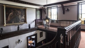 A grand staircase with ornate railings, a large framed painting, and a chandelier. - A former hotel set deep in the Dorset countryside in a small village (Chettle)