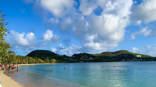 A beach with clear water, a sandy shore, and a hilly landscape in the background. - Charming vacation home (Sainte-Anne)