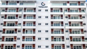 A multi-story building with a modern architectural design, featuring a prominent logo and the name 'THE GALLERY' on the facade. - Immaculate 1-bed Apartment in the Heart of Accra (Accra)