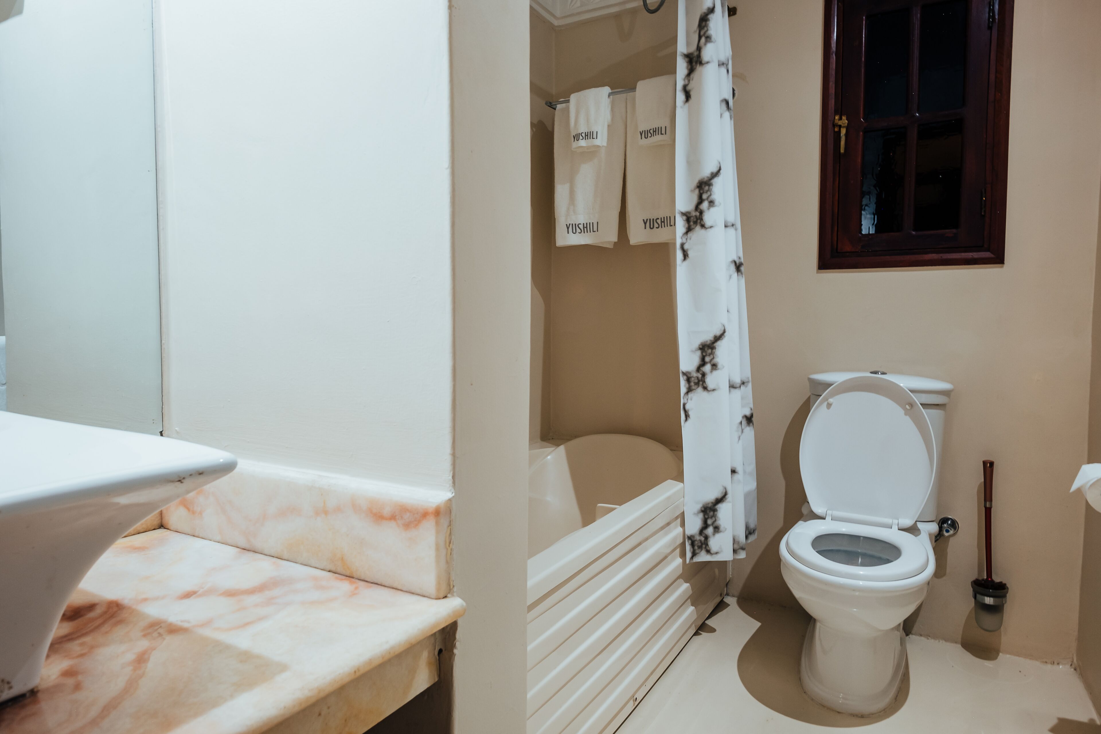 Un baño con inodoro, lavabo y cortina de ducha.