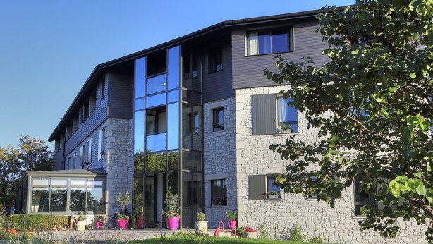 A modern two-story building with a stone facade and large windows. - Hotel Les Grains D'argent (Dizy)