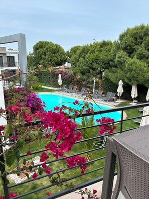 A pool area with lounge chairs and a view of a modern building. - Malta Bodrum (Bodrum)