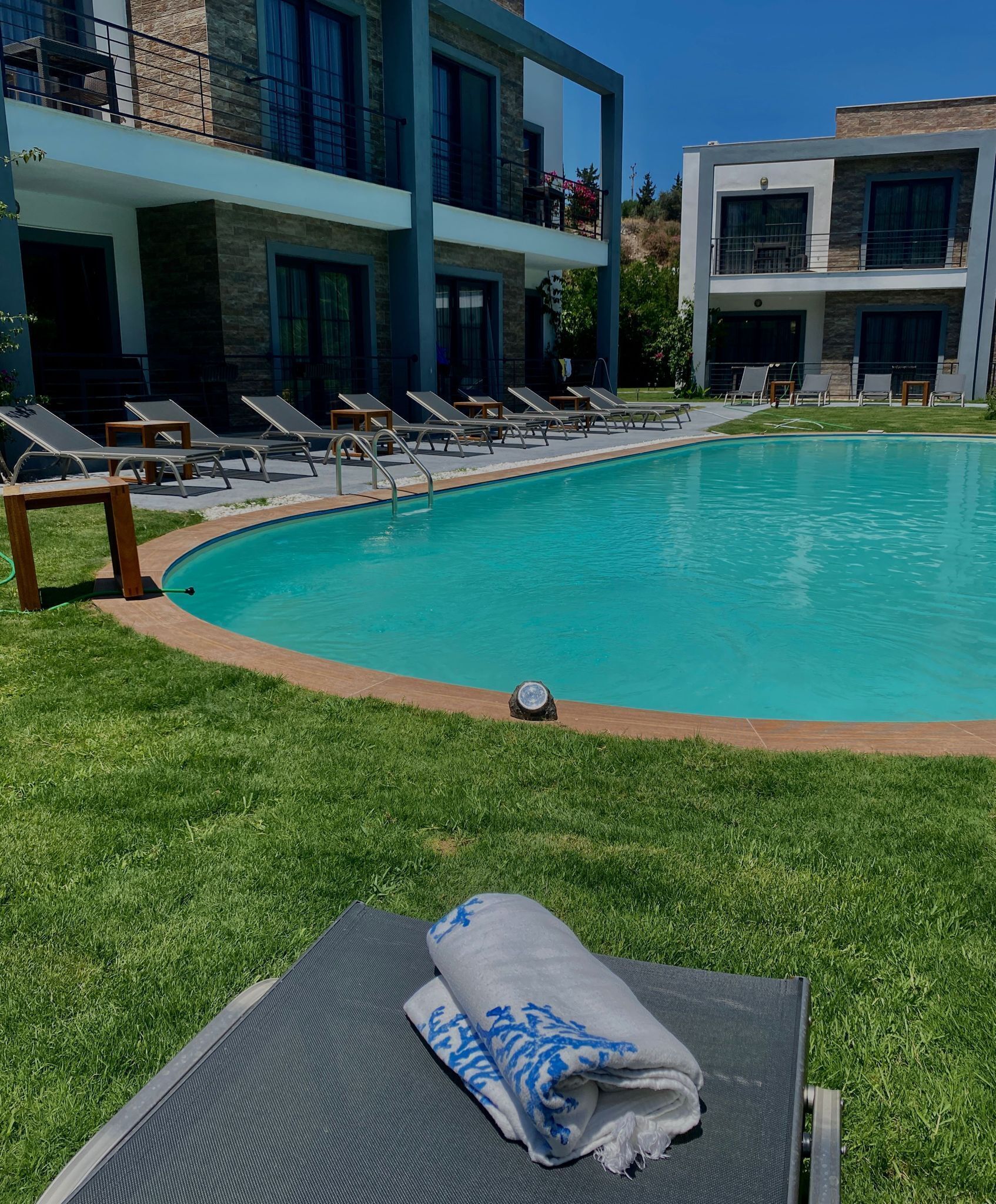 Un espace aménagé au bord de la piscine, avec des chaises longues et des serviettes.
