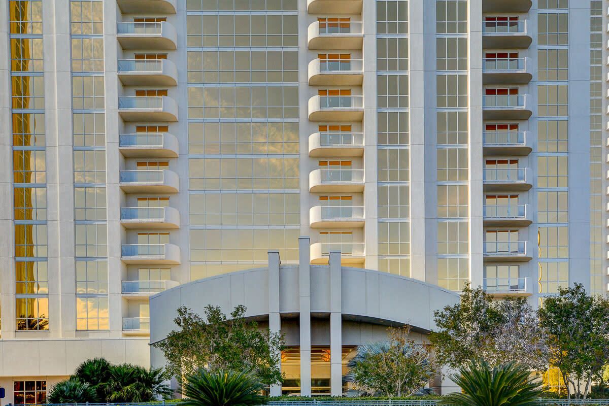 Um hotel moderno com varandas e entrada curva.