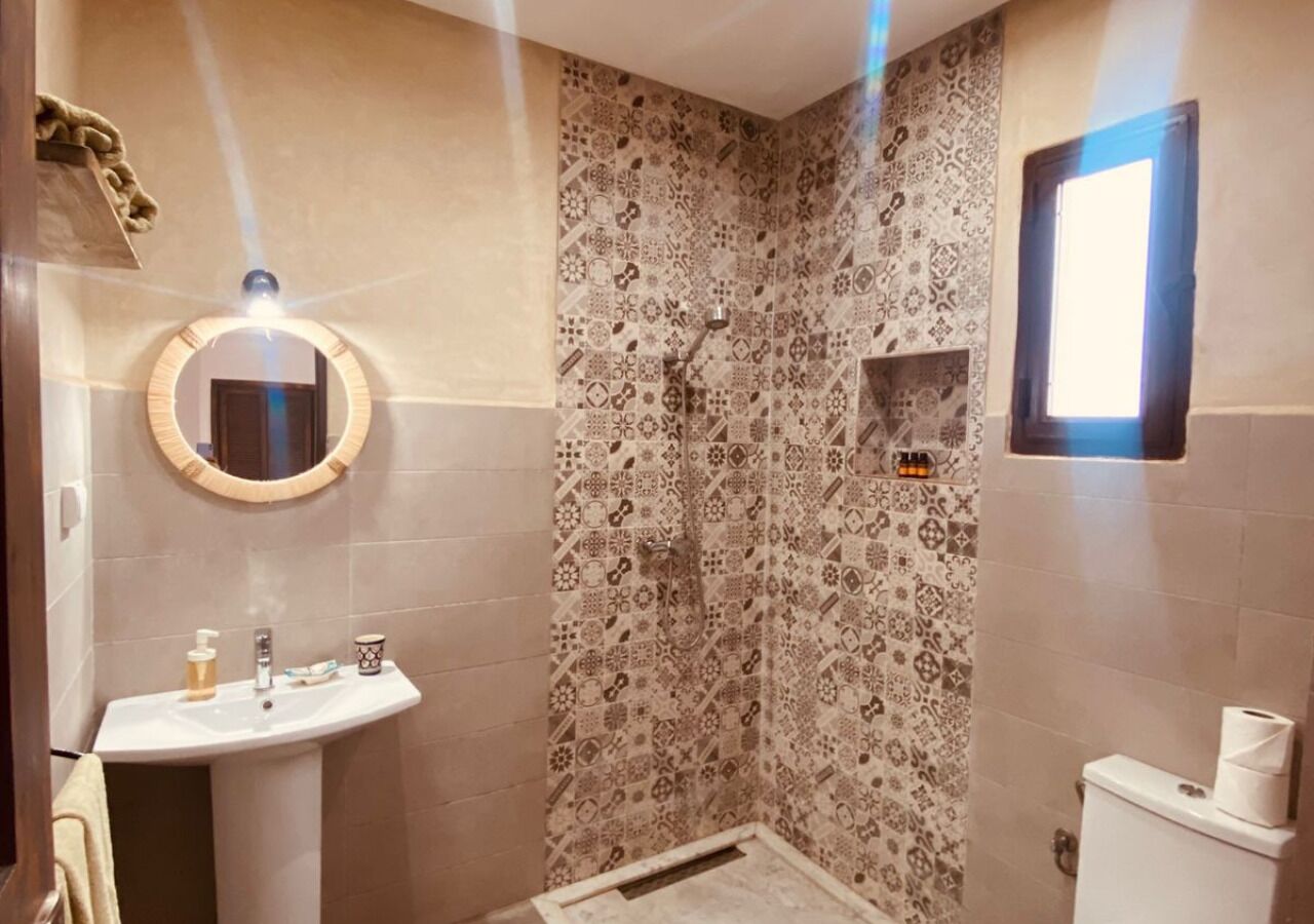 A bathroom with a shower, a sink, and a toilet.