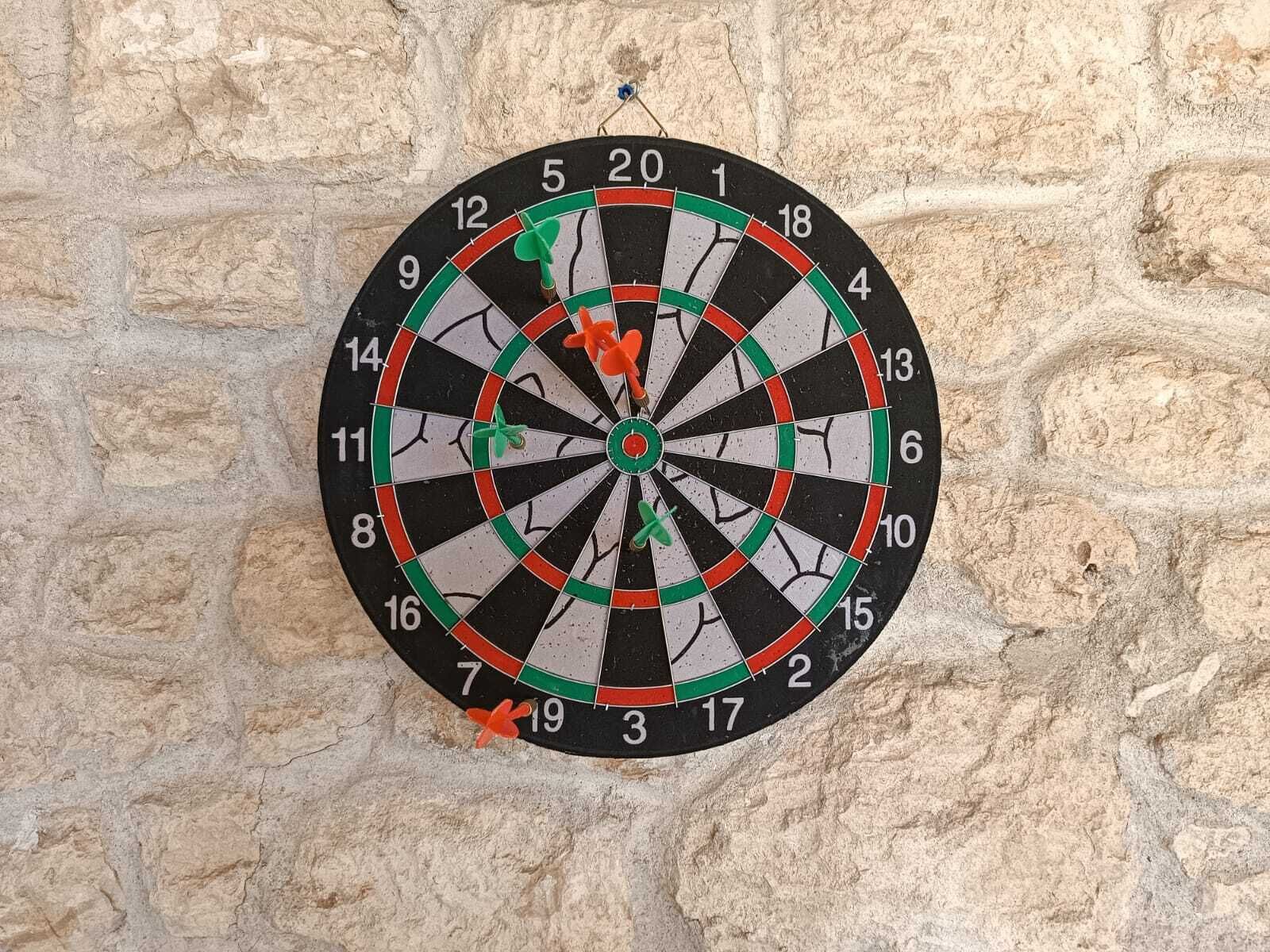 Un dardo colgado en una pared de piedra con textura.