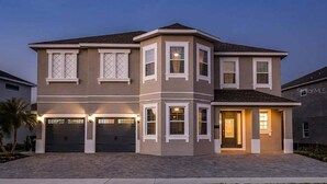 A two-story house with a garage, a covered entryway, and a landscaped driveway. - Last Minute Disney! Private Pool, Hot Tub, Game Room & Themed Bedrooms. Book Now! #47929 (Orlando)