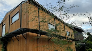 Een modern houten gebouw met grote ramen en een schuin dak.