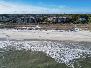 A beach with a clear view of a multi-story building in the background. - Sunset Rentals | Island Club 126 (Hilton Head Island)