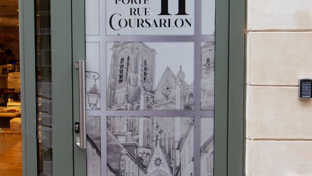 A door with a glass panel displaying a building facade and the text "Porte Rue Coursarlon 11". - Le Coursarlon (Bourges)