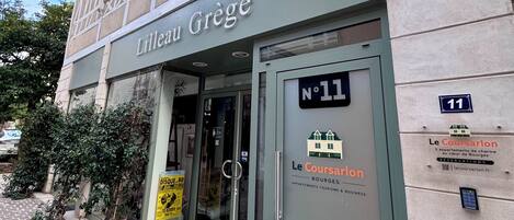 Un edificio con un letrero que dice 'Lilleau Grège' y 'Le Coursarlon', indicando una zona comercial o residencial.