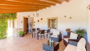 An outdoor patio area with a dining table, chairs, and a sofa. - Villa Viva Pollenca - Beautiful Stone built mallorcan villa (Pollenca)