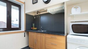 Una cocina moderna con lavadora integrada, una ventana con vistas y un frutero en la encimera.