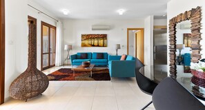 Ein modernes Wohnzimmer mit einem blauen Sofa, einem Couchtisch und einer dekorativen Vase.