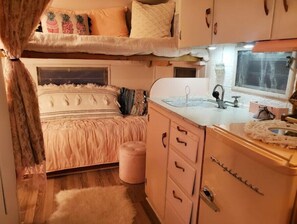 Cozy retreat with a bunk bed, kitchenette, and vintage cabinetry.