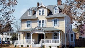 A two-story house with a porch, multiple windows, and a chimney. - Armistead House (Williamsburg)