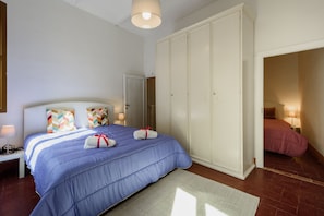 A bedroom with a large bed, a wardrobe, and a nightstand with a lamp. - Santa Maria Novella Classic by Mmega (Florence)
