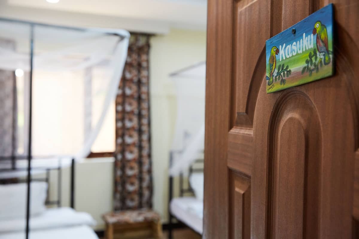 A room with a bed, a curtain, and a sign on the door.