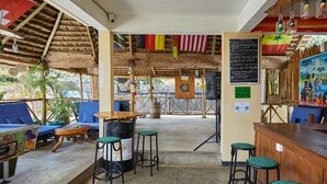 Zona de bar con taburetes, un dardo y una pizarra de menú.