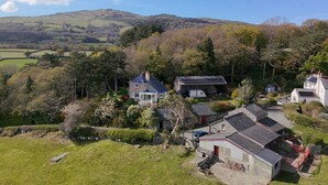 A rural landscape with houses surrounded by greenery and hills. - Eryl - Three Bedroom Cottage, Sleeps 5 (Rowen)