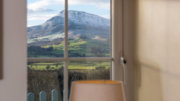 A window view of a mountain landscape with a door frame and a lamp post in the foreground. - The Barn - One Bedroom Cottage, Sleeps 2 (Bala)