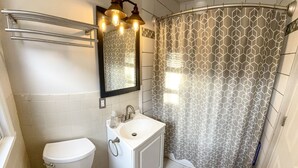 Ein Badezimmer mit Toilette, Waschbecken und Duschvorhang.