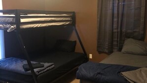 A room with bunk beds, a window with curtains, and a ceiling light. - Stuttgart Lodge (Stuttgart)