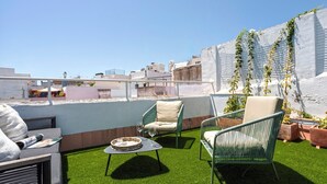 A rooftop terrace with artificial grass, seating, and potted plants. - Genteel Home Santas Patronas III (Seville)
