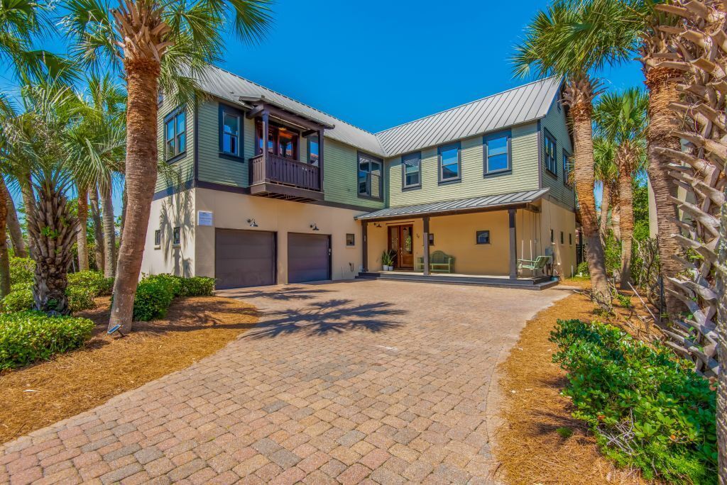 A two-story house with a covered patio and a driveway.