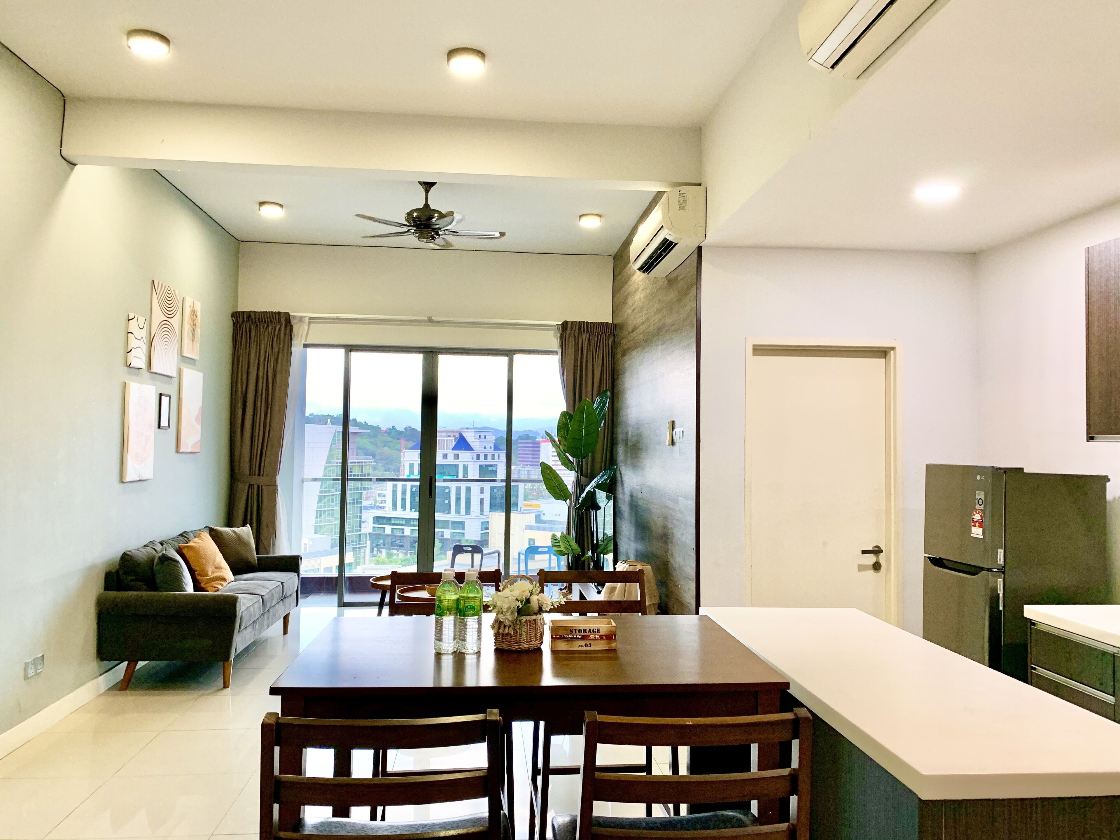 Un apartamento moderno con comedor, cocina y un amplio ventanal con vistas a la ciudad.
