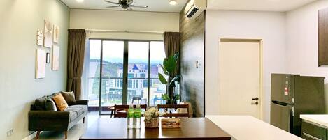 Un apartamento moderno con comedor, cocina y un amplio ventanal con vistas a la ciudad.