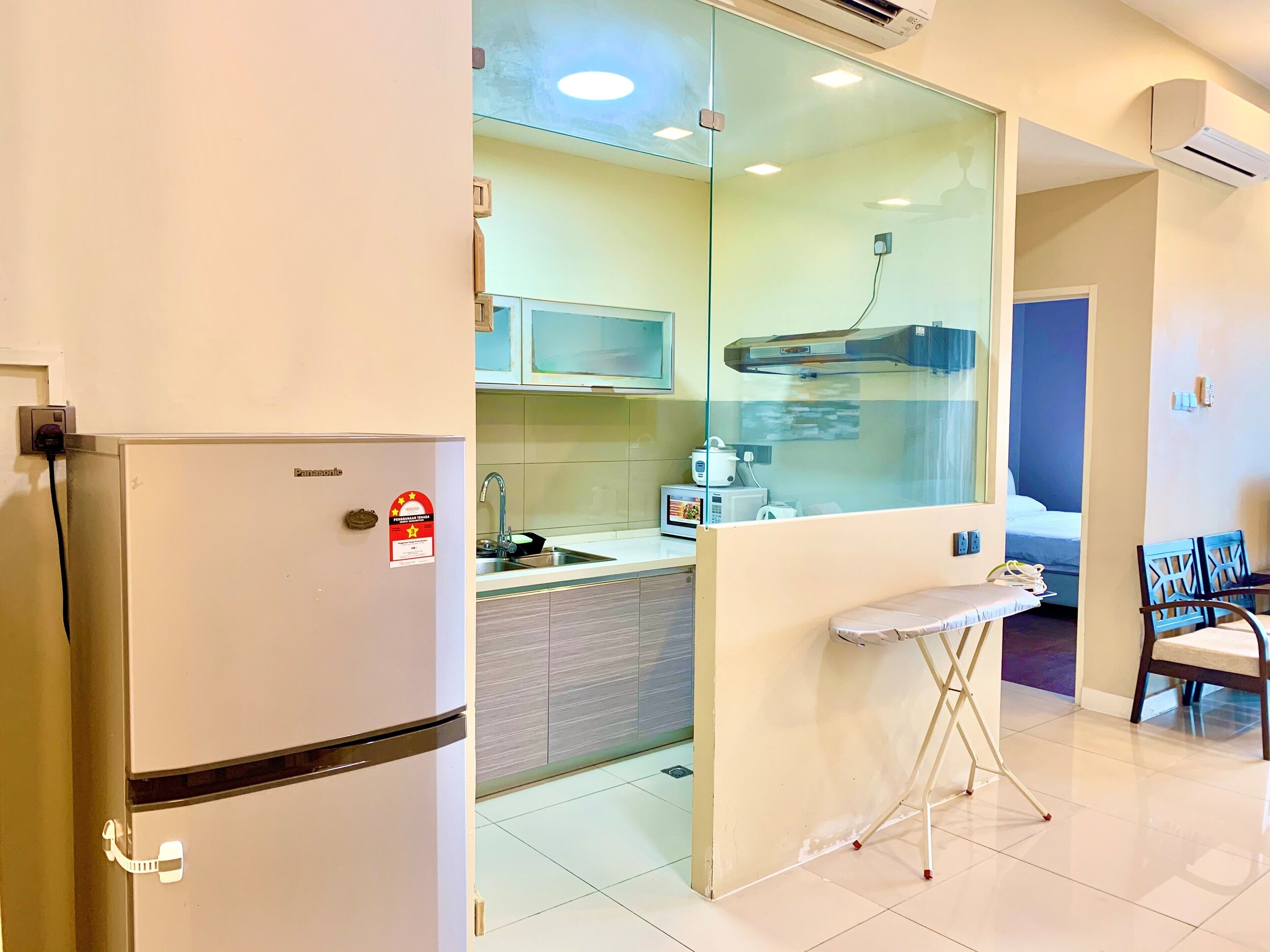 Una cocina compacta equipada con refrigerador, microondas, pileta y una pequeña mesa.