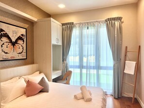 A hotel room with a bed, a chair, a ladder, and a window with curtains. - Deco Home Imago The Loft (Kota Kinabalu)