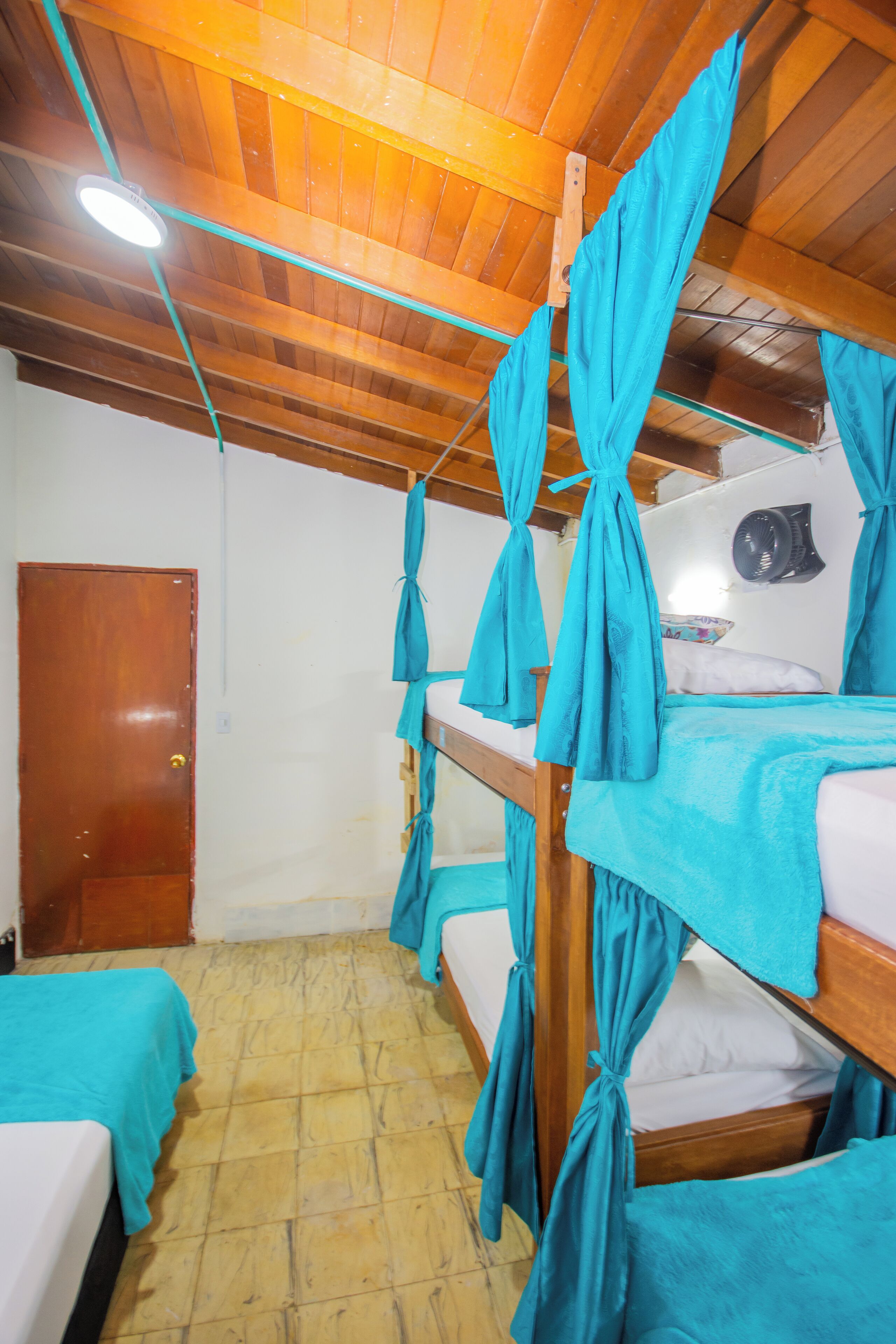 Ein Zimmer mit Stockbetten, Holzboden und einer Tür.