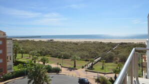 A view from a balcony overlooking a beach, with a clear sky and a distant ship visible on the water. - ESPIGÓN LEVANTE 8 - Two Bedroom Apartment, Sleeps 5 (Punta del moral)