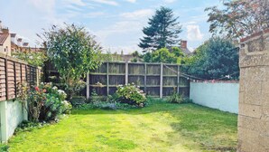 A well-maintained garden with a wooden fence, a variety of plants, and a clear sky. - 3 bedroom accommodation in Sheringham (Sheringham)